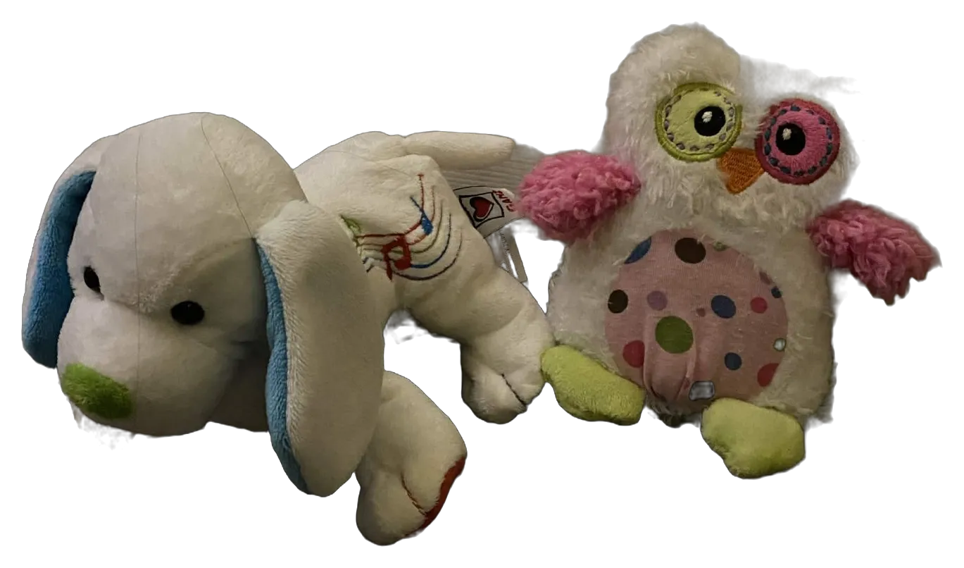 A well-loved white puppy with blue ears and a fuzzy polka-dot owl